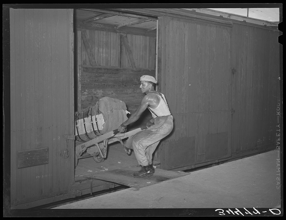  unloading bale of cotton from railroad car. Compress, Houston, Texas by Russell Lee