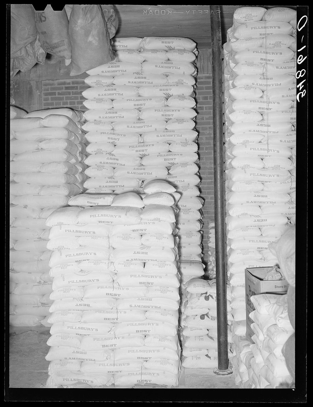 Stacks of flour in storage. Wholesale grocery, San Angelo, Texas by Russell Lee