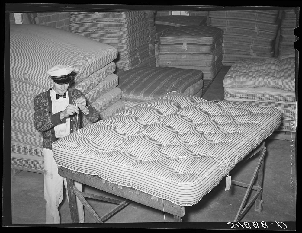 Piercing a mattress in tufting. Mattress factory. San Angelo, Texas by Russell Lee