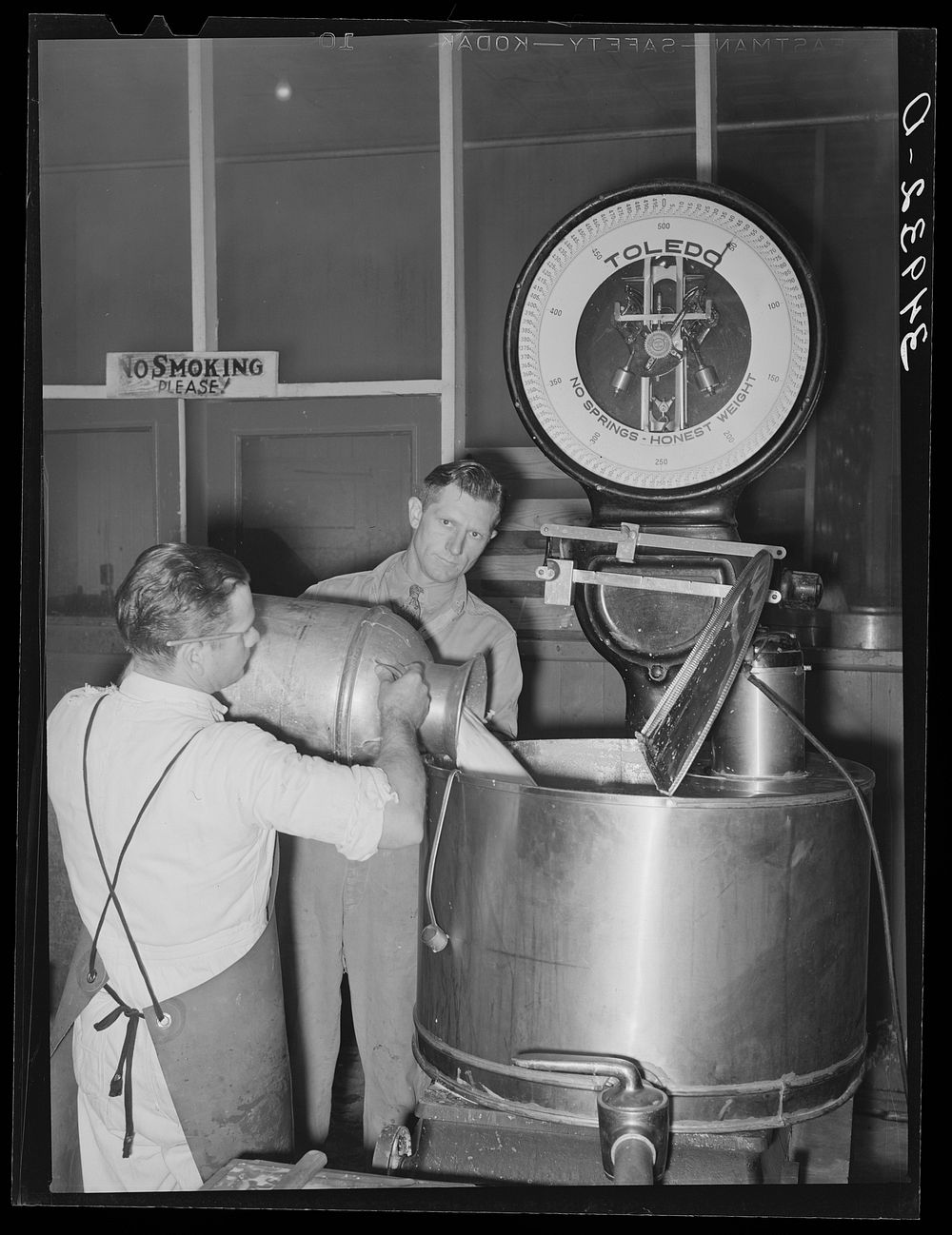 Unloading milk at creamery. San Angelo, Texas. The milk is weighed in this large kettle by Russell Lee