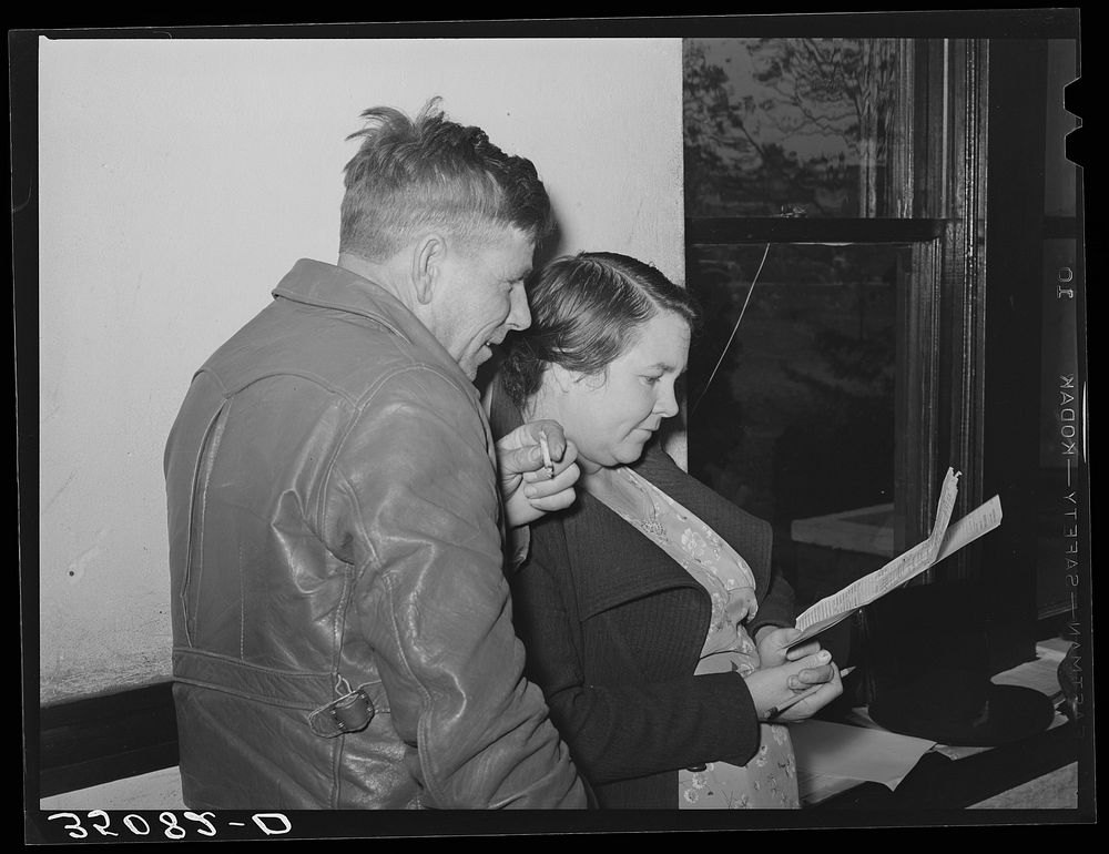 FSA (Farm Security Administration) client and his wife studying farm and home plan at meeting. Mason, Texas by Russell Lee