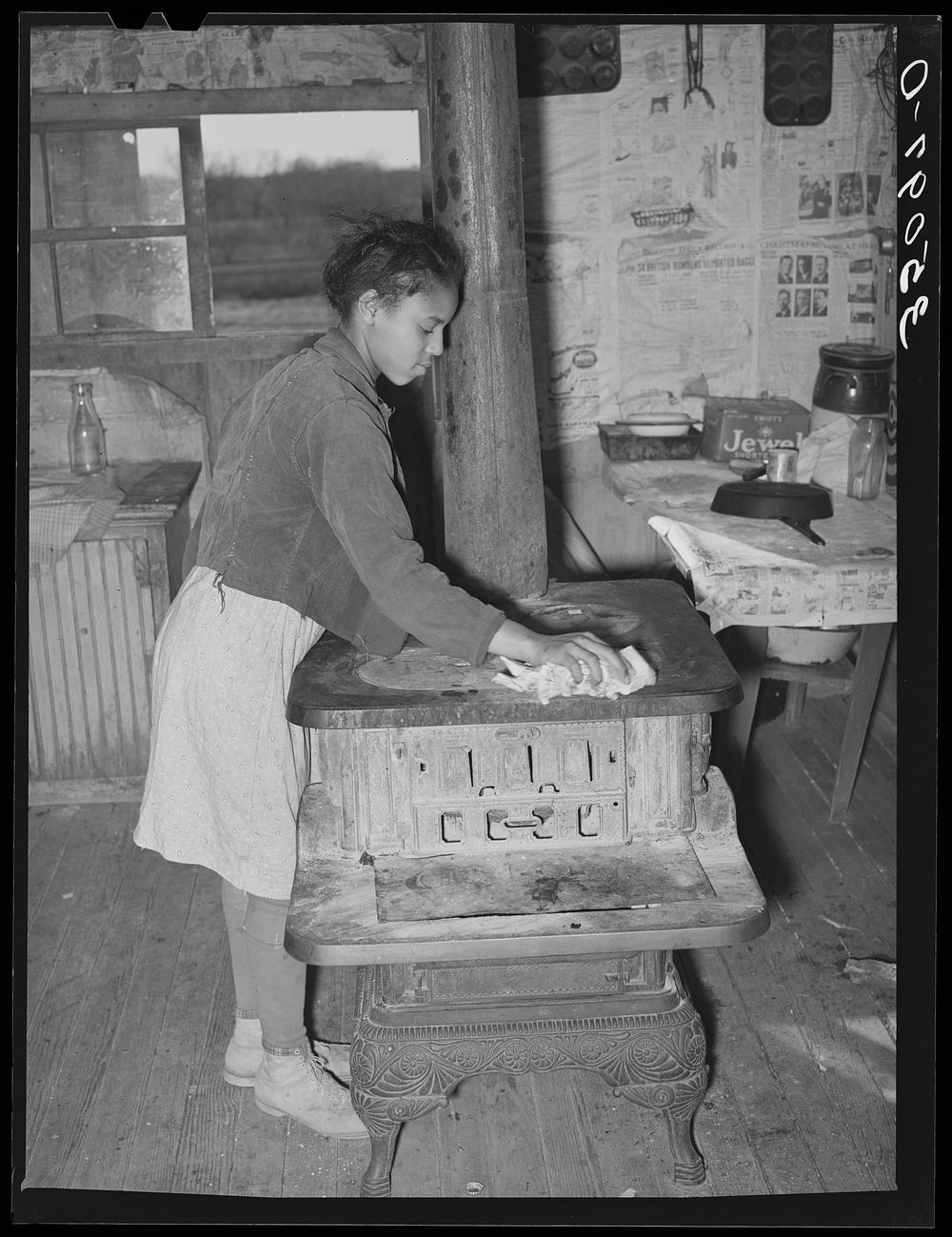 Daughter of Pomp Hall,  tenant farmer, cleaning off top of cook stove. Creek County, Oklahoma. See general caption number 23…