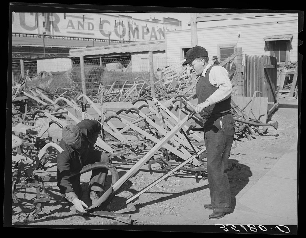 Salesman showing walking plow to prospective buyer. Oklahoma City, Oklahoma by Russell Lee