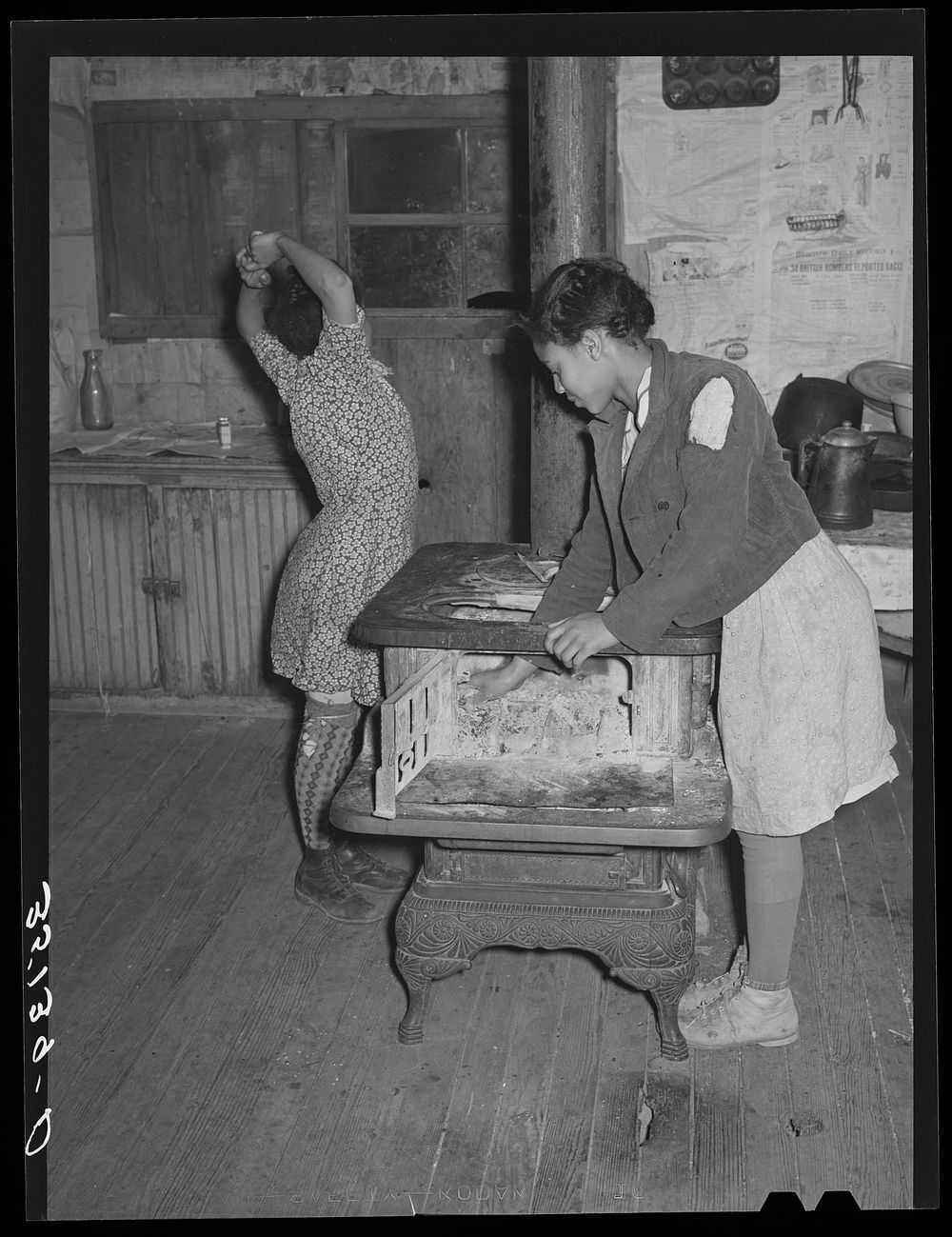 [Untitled photo, possibly related to: Daughter of Pomp Hall, tenant farmer, building fire in the morning. Smoke is in her…