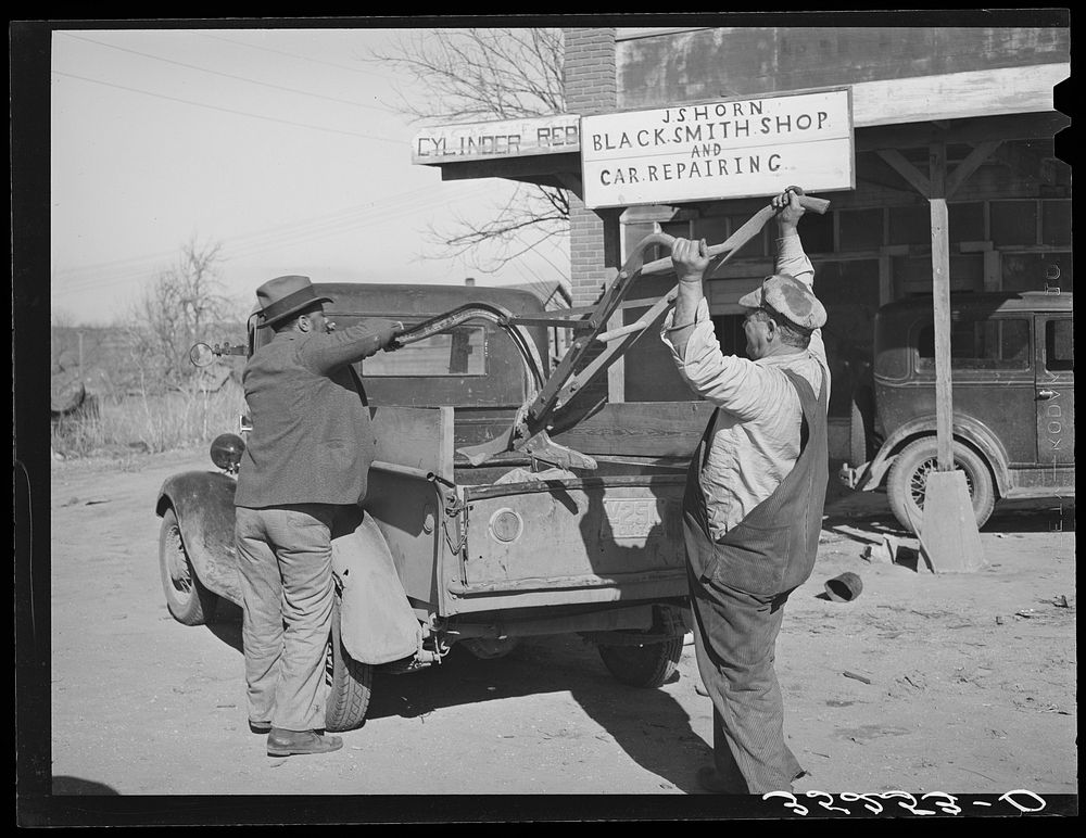 Pomp Hall,  tenant farmer, and smith loading Pomp's plow into truck after it has been sharpened. Depew, Oklahoma. See…