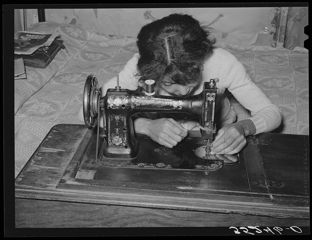 Wife of Pomp Hall,  tenant farmer, threading sewing machine. She makes practically all of the clothing for her family with…