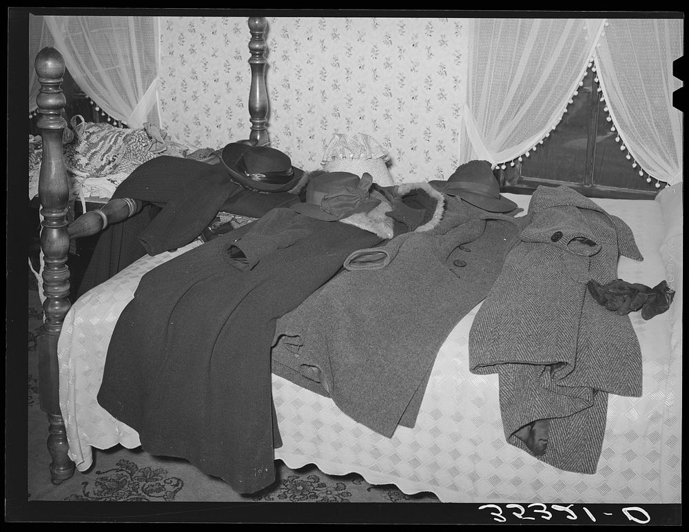 Coats of members of home demonstration club on bed during a meeting. McIntosh County, Oklahoma by Russell Lee
