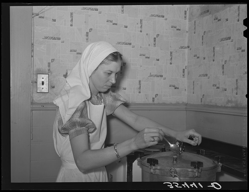 FSA (Farm Security Administration) supervisor giving a demonstration of pressure canning before a group of FSA officials at…