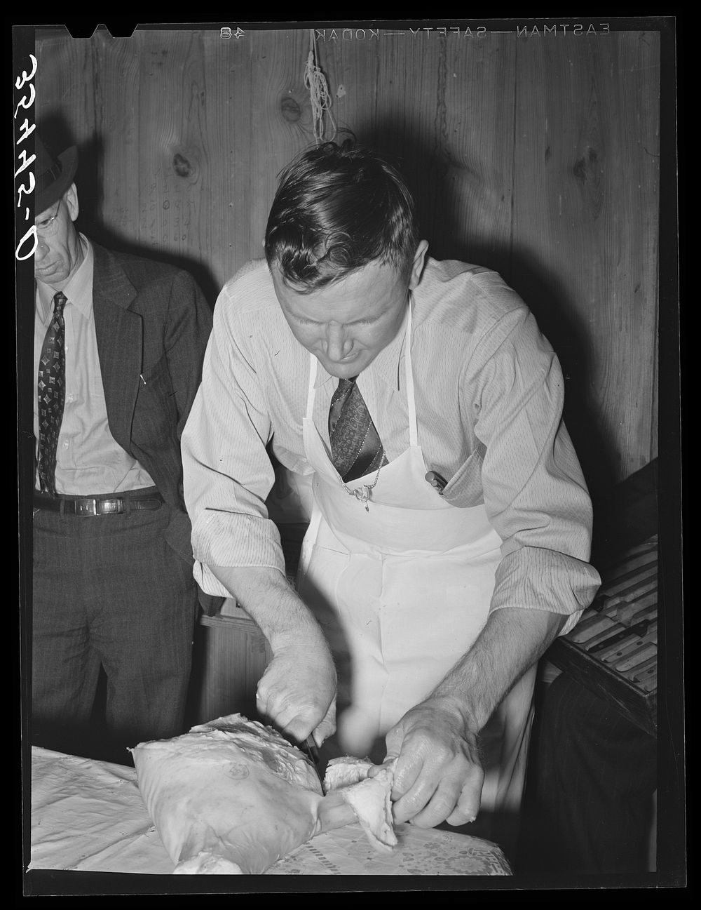FSA (Farm Security Administration) supervisor who was formerly a meat cutter at a large packing plant giving a demonstration…