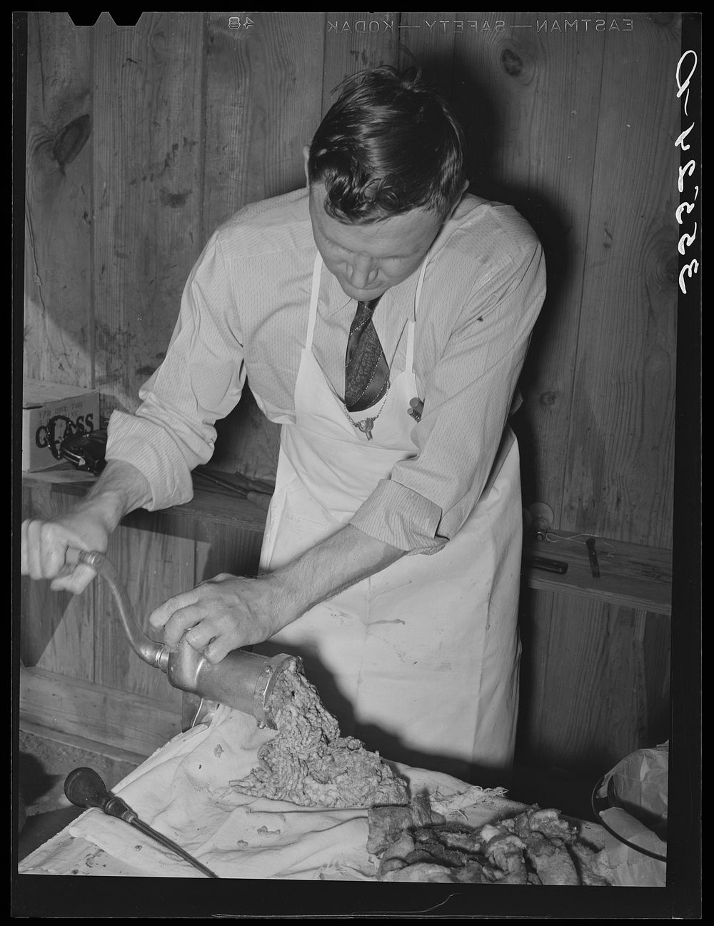 FSA (Farm Security Administration) supervisor making sausage during a meat cutting demonstration before FSA officials and…