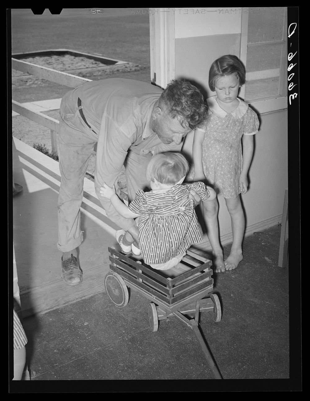 Migratory agricultural worker delivers his child to the WPA (Work Projects Administration) nursery school at the Agua Fria…