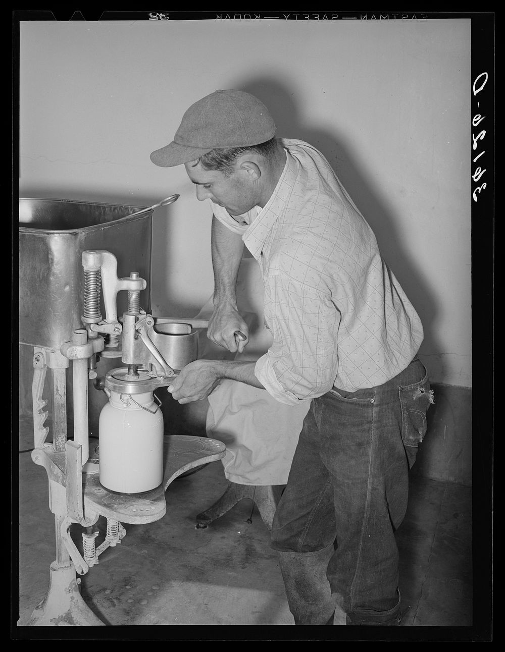 Member of the Arizona part-time farms, Chandler Unit, filling milk bottles in the dairy of the farm. Maricopa County…