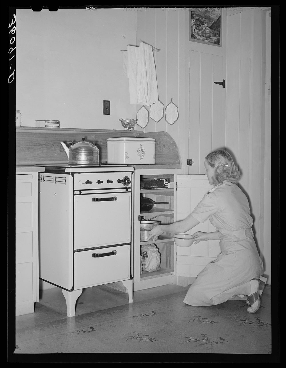 Wife of member of the Arizona part-time farms, Chandler Unit, Maricopa County, Arizona, at her kitchen stove by Russell Lee