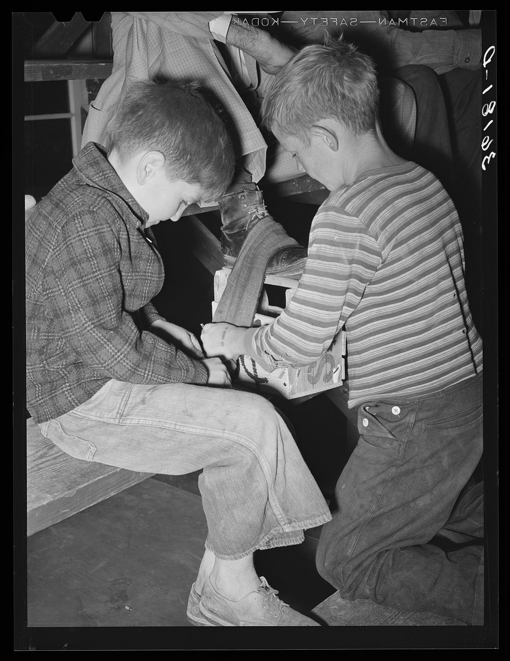 Children of migrant agricultural workers make some spending money by shining shoes at the Agua Fria labor camp. Arizona by…