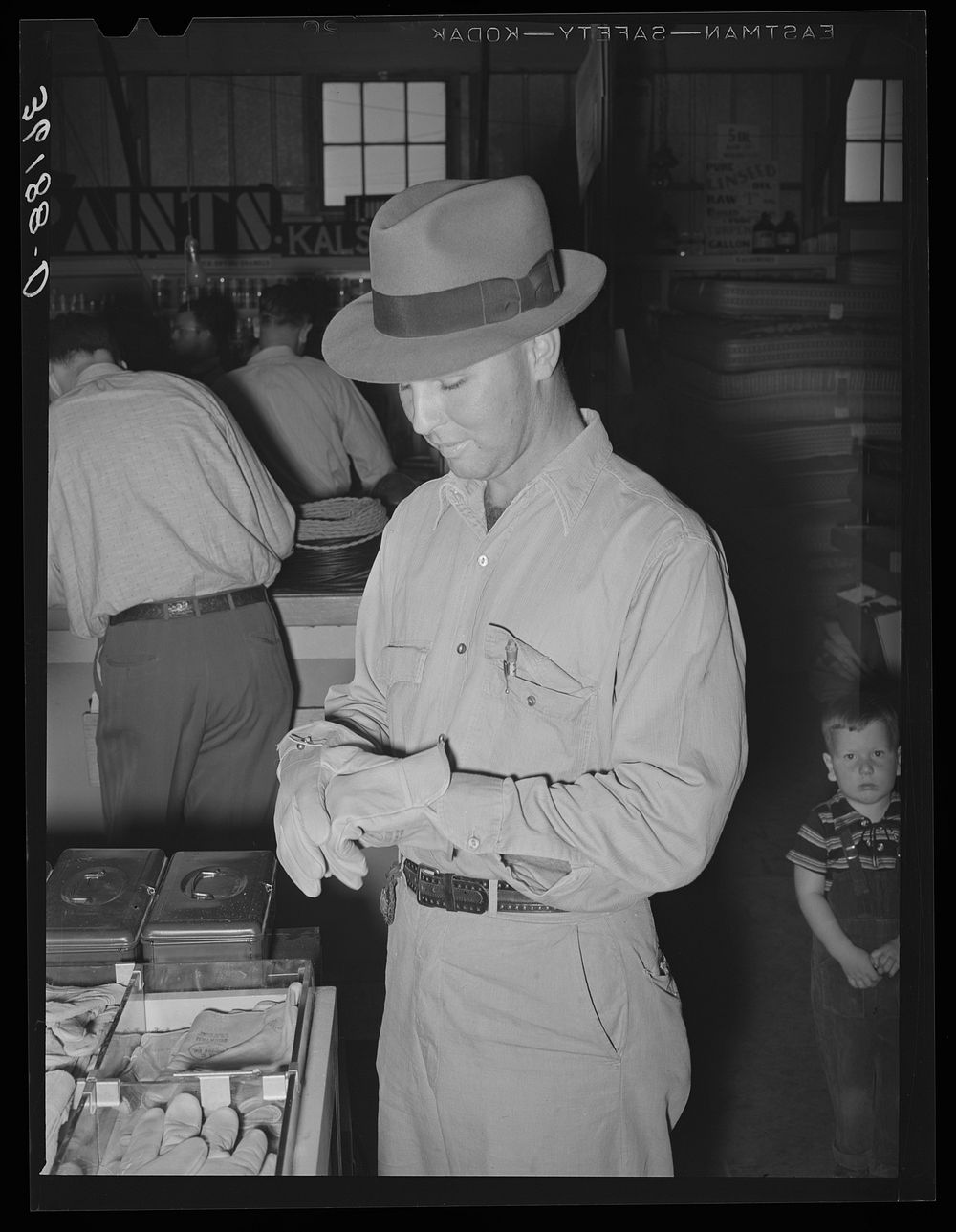 Member of the United Producers and Consumers Cooperative of Phoenix, Arizona, trying on a pair of gloves by Russell Lee