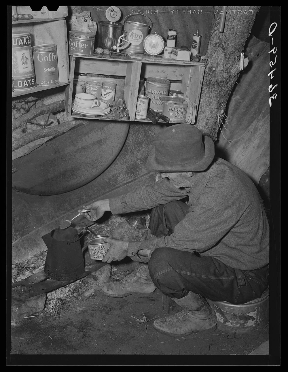 Eugene Davis, gold prospector, making a pot of coffee in his shack on his diggings. Pinos Altos, New Mexico by Russell Lee