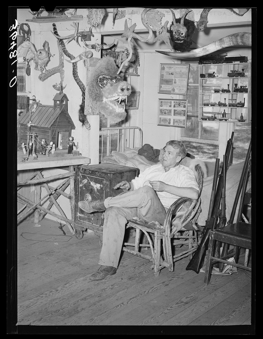 Homer Tate sitting among his creations. Safford, Arizona by Russell Lee