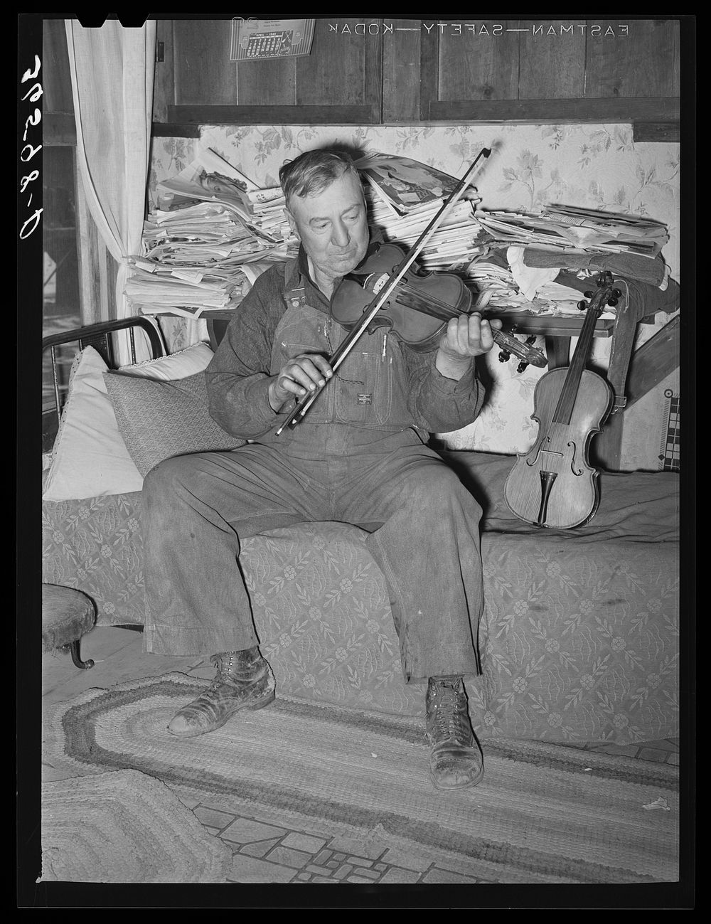 George Hutton, farmer from Maud, Oklahoma, playing his violin which he made. Pie Town, New Mexico by Russell Lee