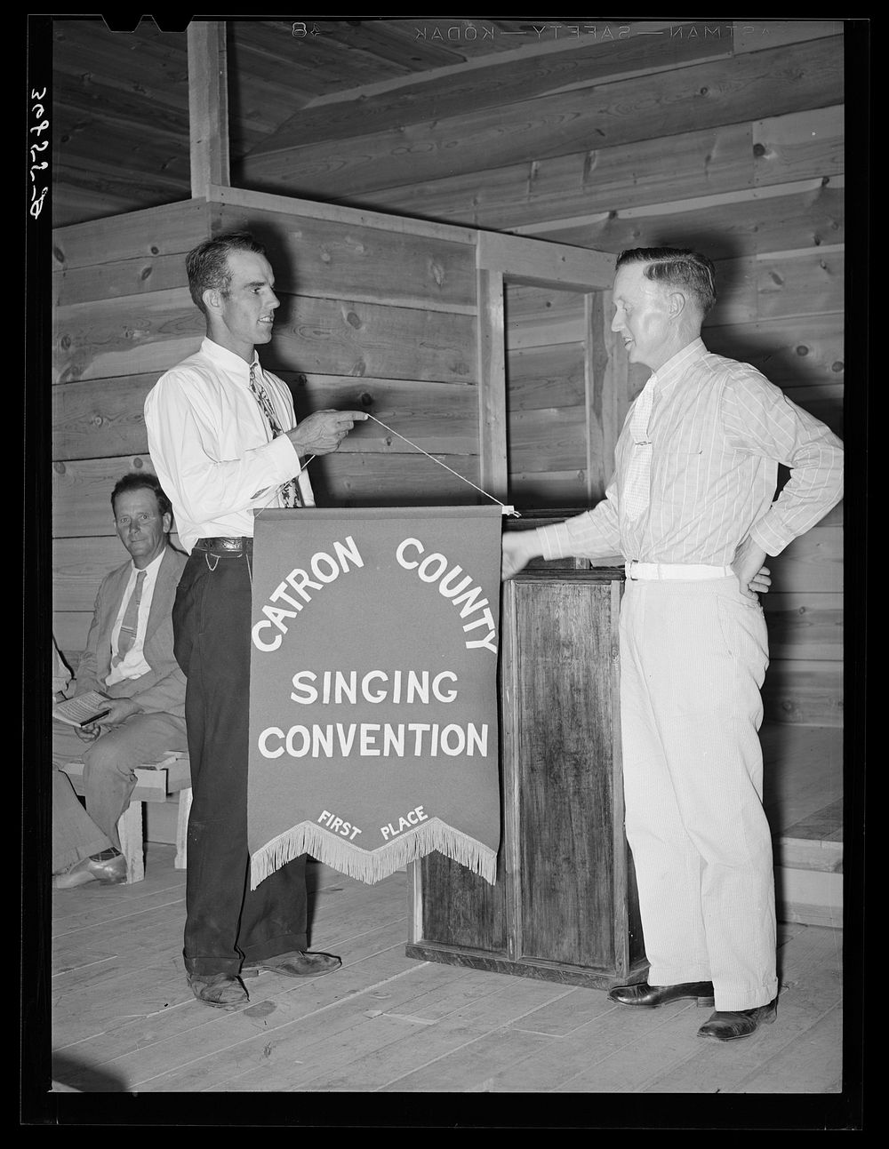 President of the singing convention. He is also a homesteader, on the right presenting the banner to Mr. Whinery as…