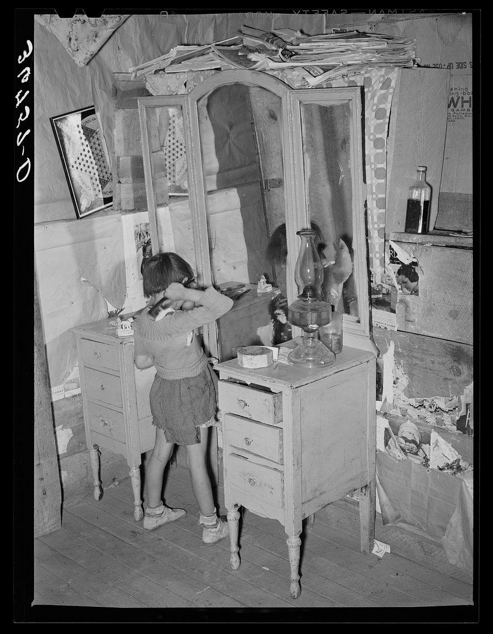 Josie Caudill, homesteader's daughter, combs her hair. Pie Town, New Mexico by Russell Lee