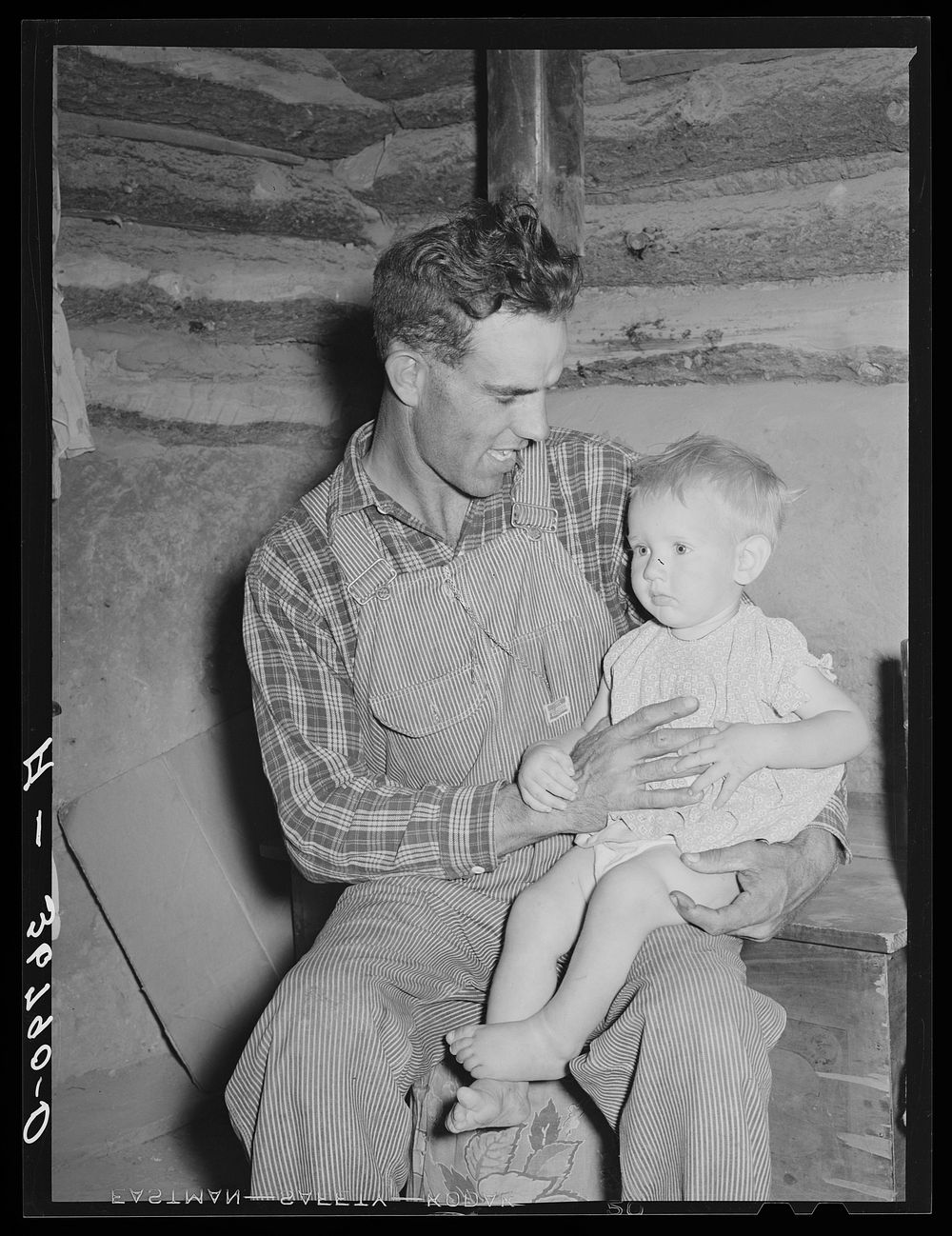 Jack Whinery, homesteader, with his baby son. Pie Town, New Mexico by Russell Lee