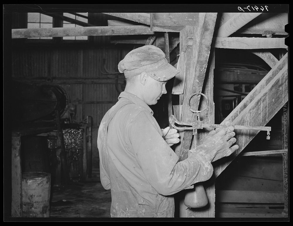 Workman weighing sample of gold ore and cyanide solution to determine if proper concentration of liquid is being maintained.…