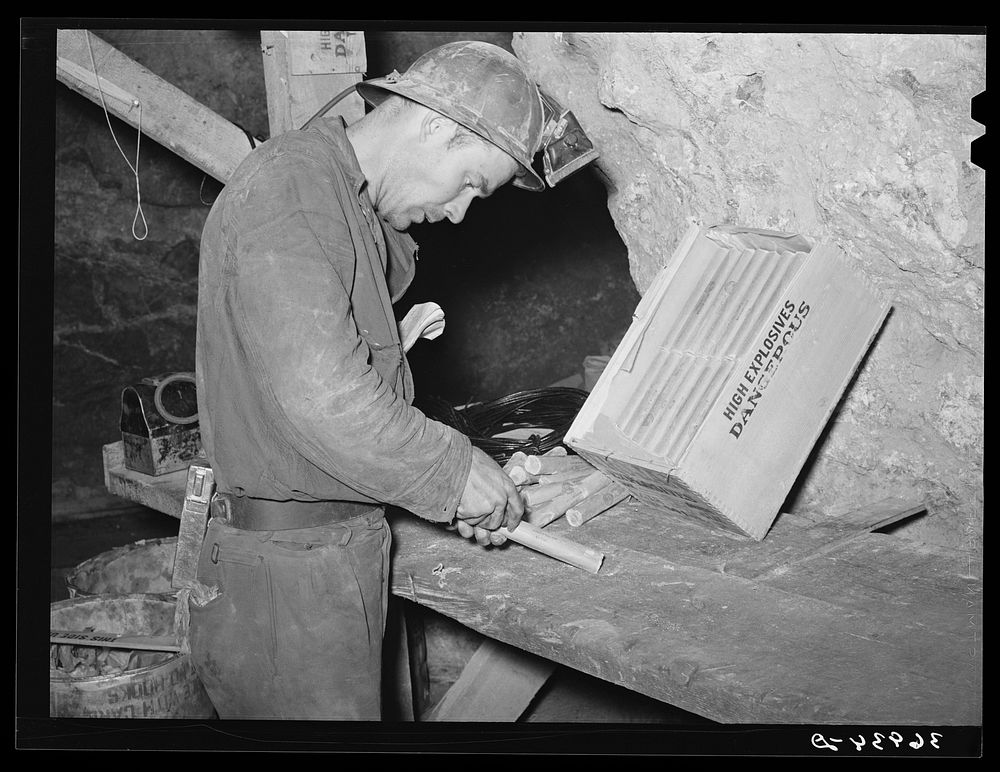 Miner inserting fuse into stick of dynamite. Mogollon, New Mexico by Russell Lee