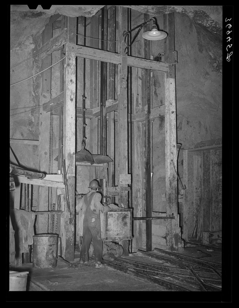 Goldminer pushing car of ore onto hoist. This is elevator to the surface from the 750-feet level. Mogollon, New Mexico by…