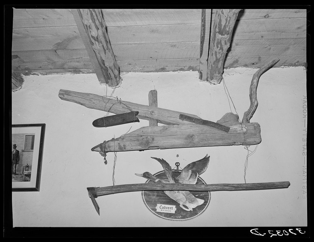 Old handmade plow and hoe in liquor store. Costilla, New Mexico by Russell Lee