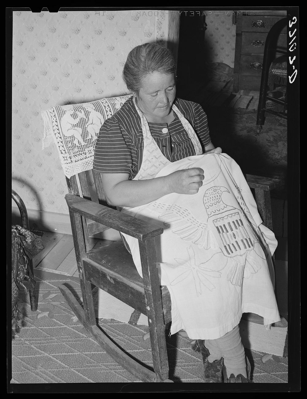 Spanish-American woman doing needlework. Many of the homes in this section show the love of the Spanish-Americans for…