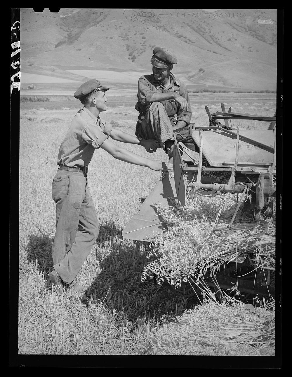 [Untitled photo, possibly related to: Neighboring farmer asking one of the members of the Olsen cooperative binder when…