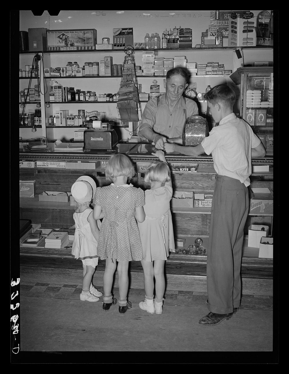 Mormon children buying candy at store. Mendon, Utah by Russell Lee