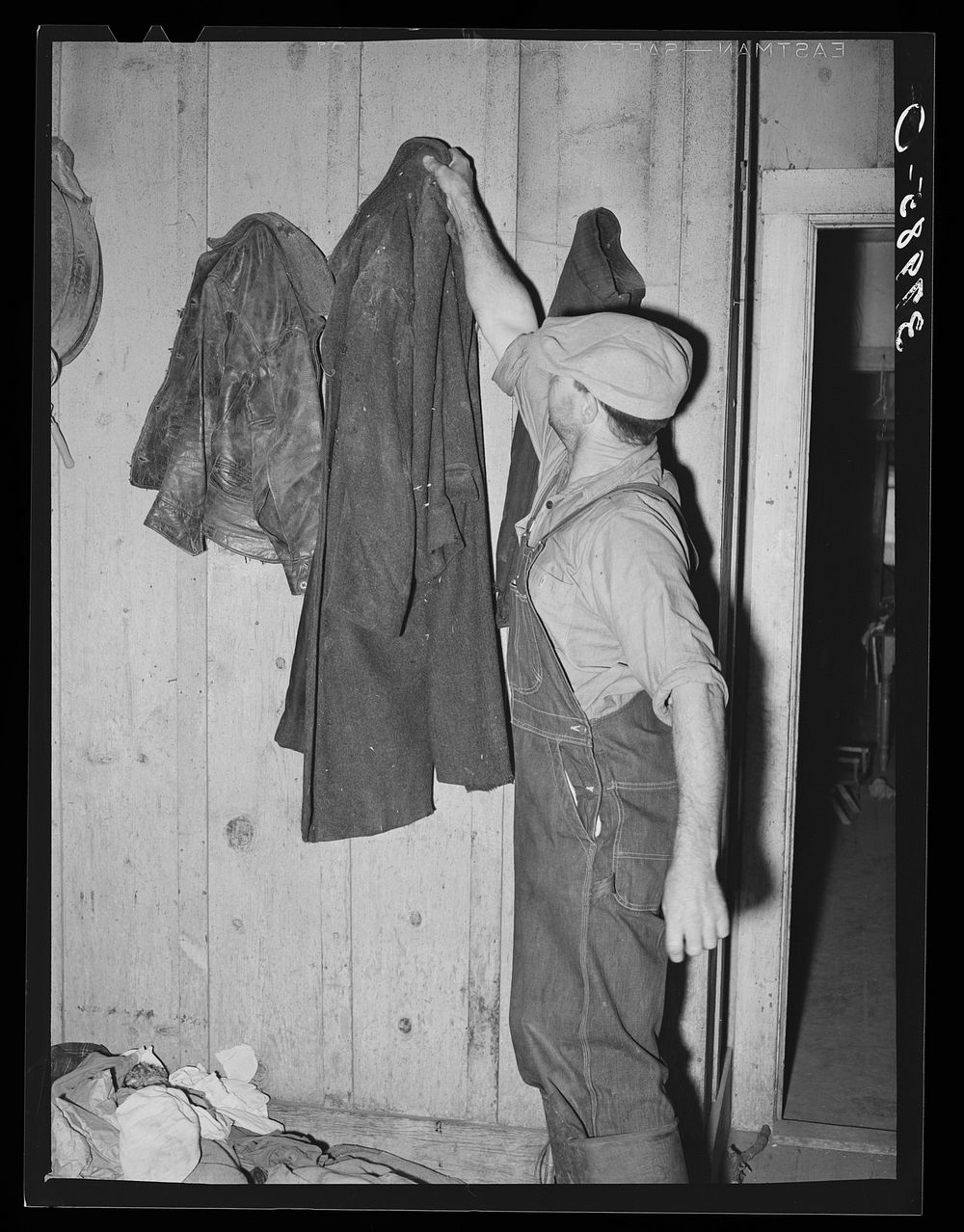 John Frost, farmer in Tehama County, California, donning his work overcoat by Russell Lee
