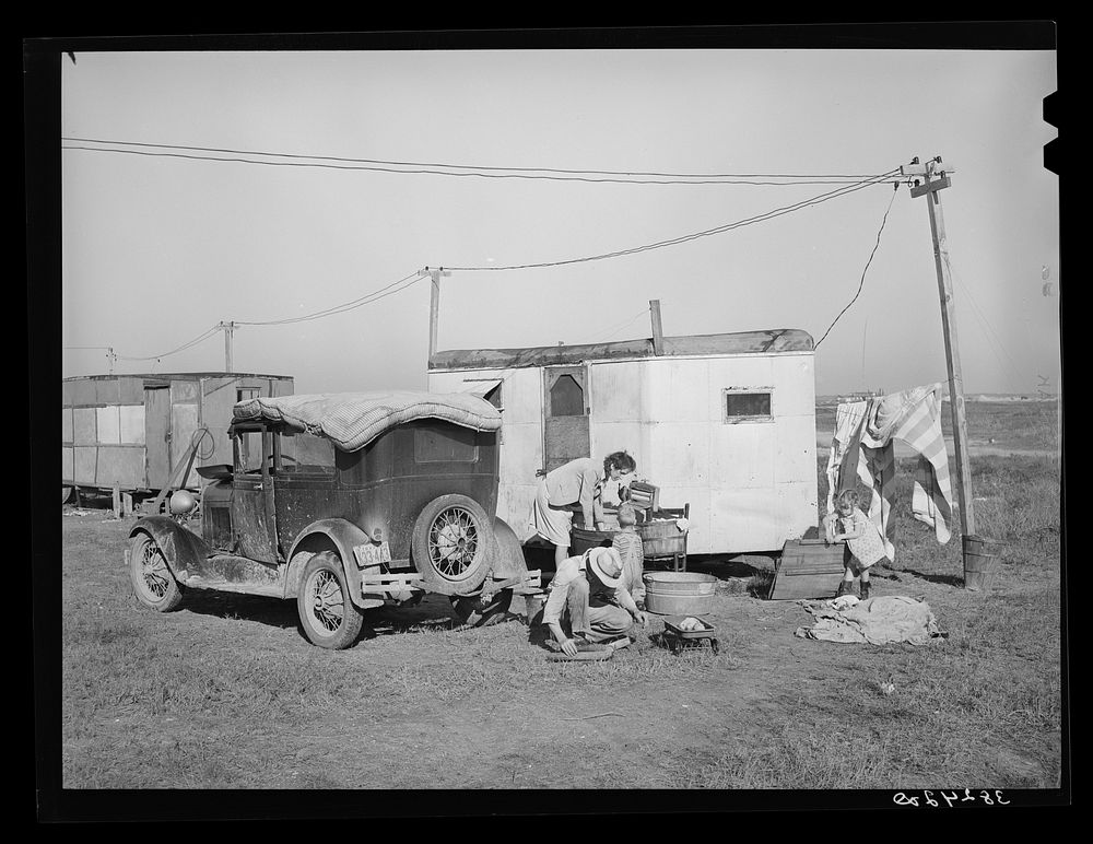 Automobile and trailer parked in trailer court. These belong to a carpenter's helper who is from the Rio Grande Valley. He…