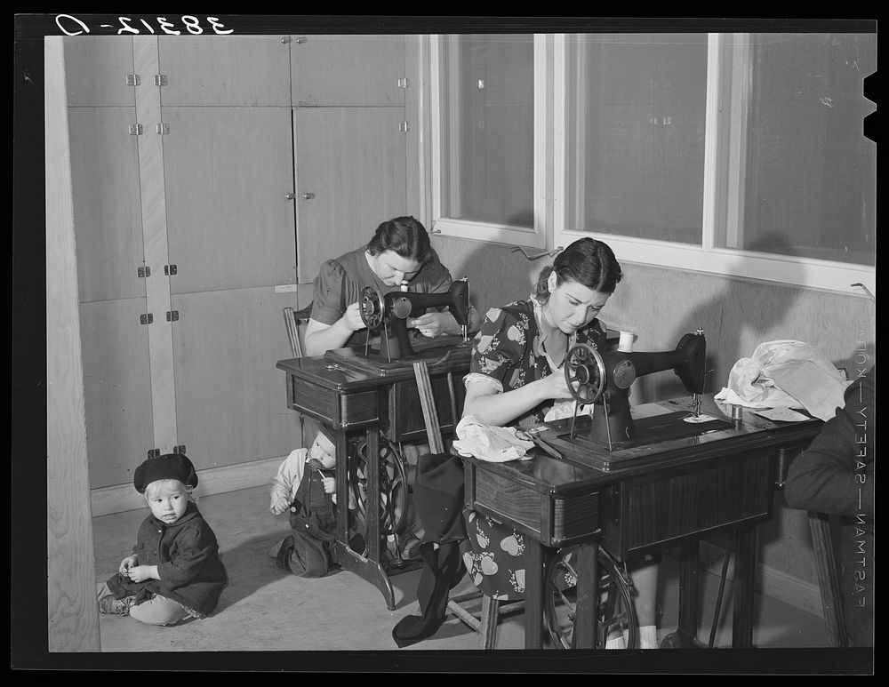 Wives of farm workers living at the Yuba City FSA (Farm Security Administration) camp sewing in the community building of…