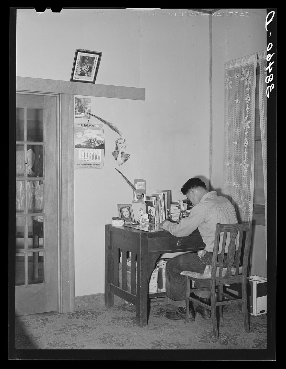 Son of Japanese fruit farmer at his desk. Placer County, California by Russell Lee