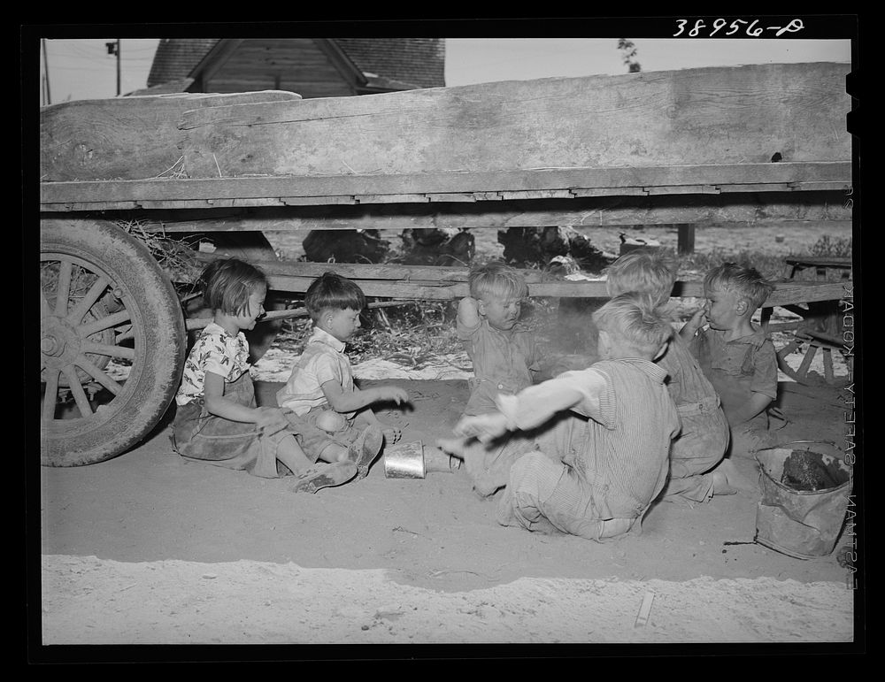 [Untitled photo, possibly related to: Children playing under wagon at the Schroder farm, FSA (Farm Security Administration)…