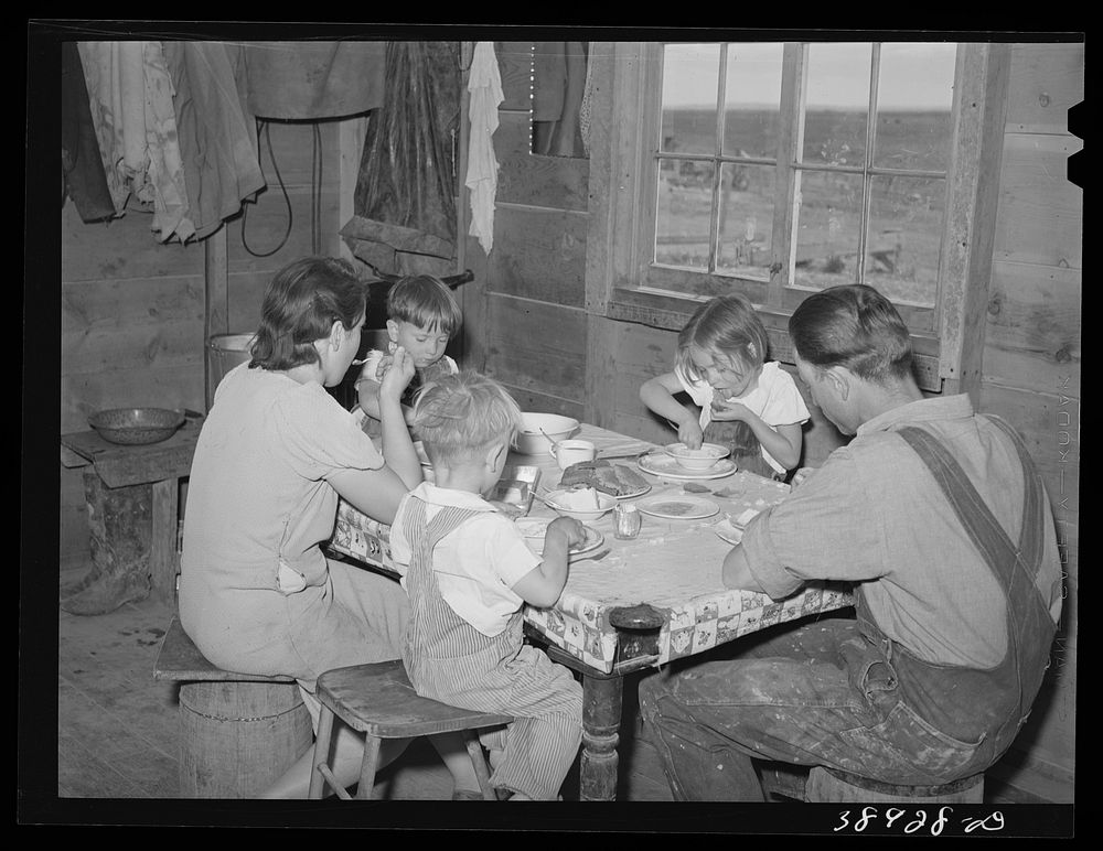The Ray Halstead family eating dinner. They are FSA (Farm Security Administration) rehabilitation borrowers on Dead Ox Flat.…
