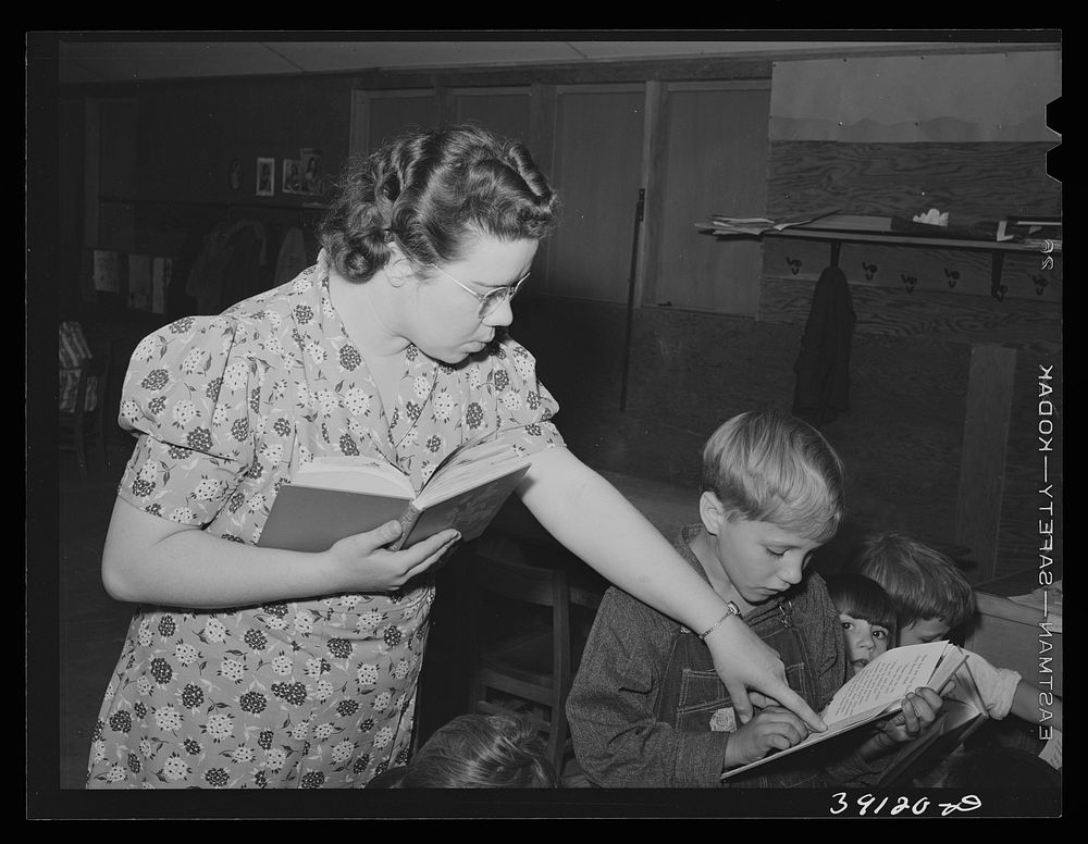 Teacher helps pupil with his reading, FSA (Farm Security Administration) camp for farm workers. Caldwell, Idaho. School is…