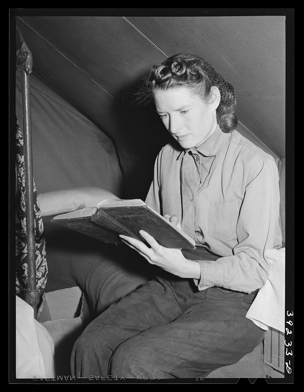 Daughter of farm worker reads her Bible. FSA (Farm Security Administration) migratory labor camp mobile unit. Wilder, Idaho…