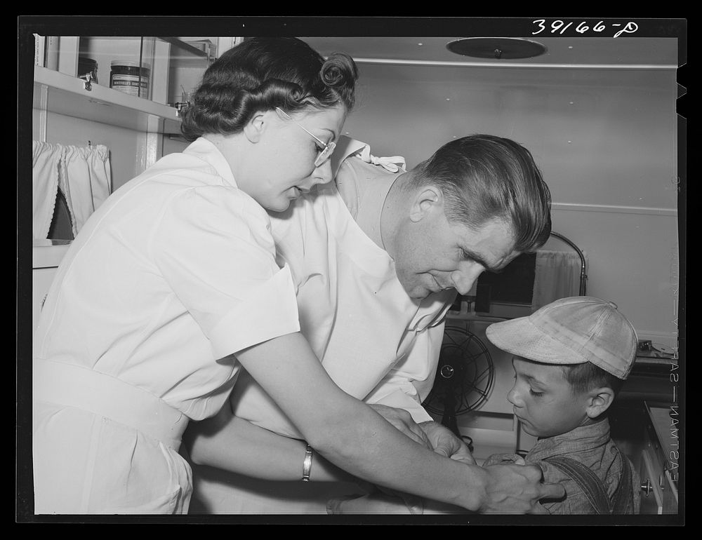 Doctor and nurse at the FSA (Farm Security Administration) migratory labor camp mobile unit. Wilder, Idaho. Doctor visits…