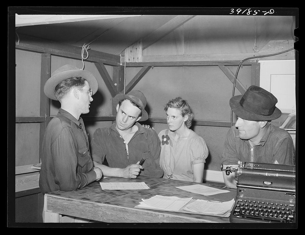 Camp manager (left) talking to newly-arrived farm workers at the FSA (Farm Security Administration) migratory labor camp.…
