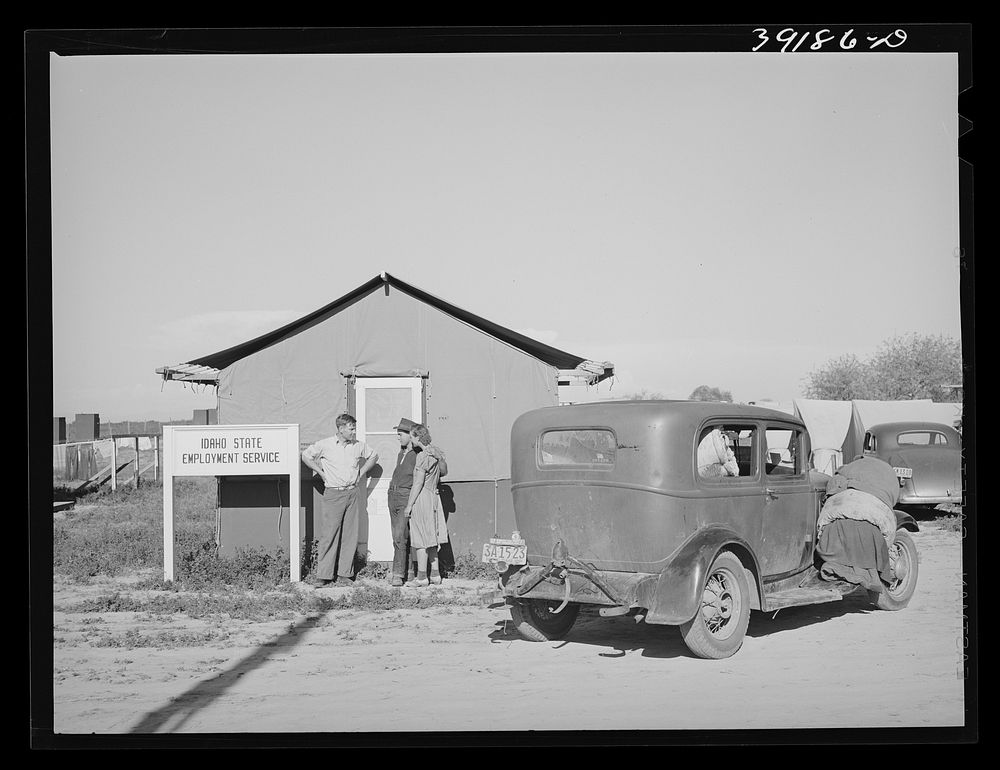 Newly-arrived farm workers talking to the Idaho state employment representative at the FSA (Farm Security Administration)…