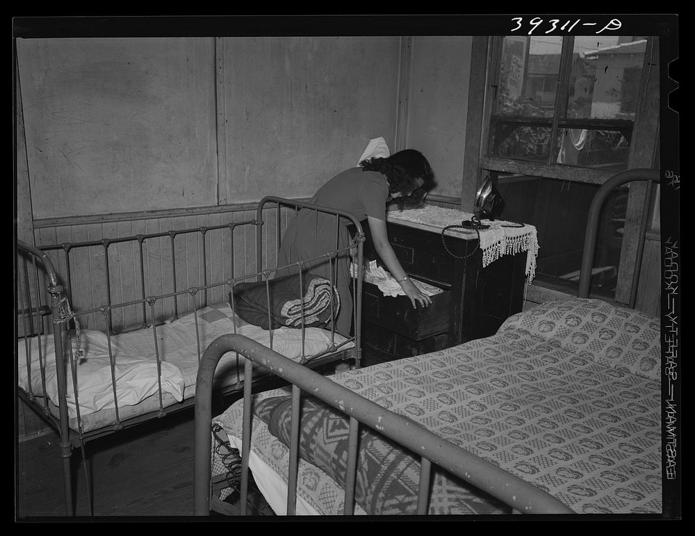 Young Mexican girl in corner of bedroom. San Diego, California by Russell Lee