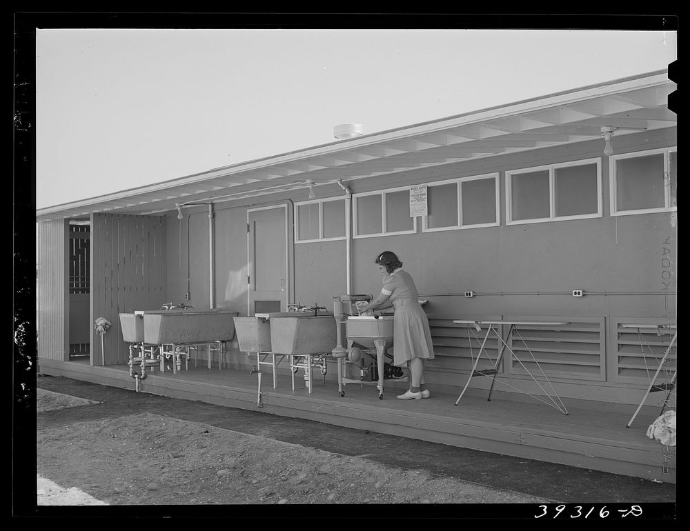 Tenant at the FSA (Farm Security Administration) camp for defense workers doing her laundry. San Diego, California by…