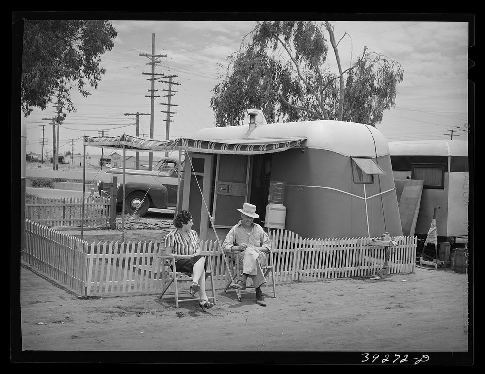 A man who works at Kearney-Mesa (construction work) and his wife in front of their trailer home. San Diego, California by…