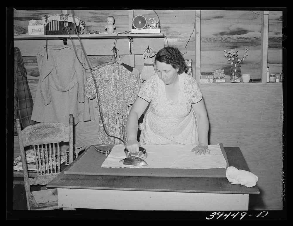 Wife of migratory farm worker ironing in shelter at the FSA (Farm Security Administration) labor camp. Caldwell, Idaho by…