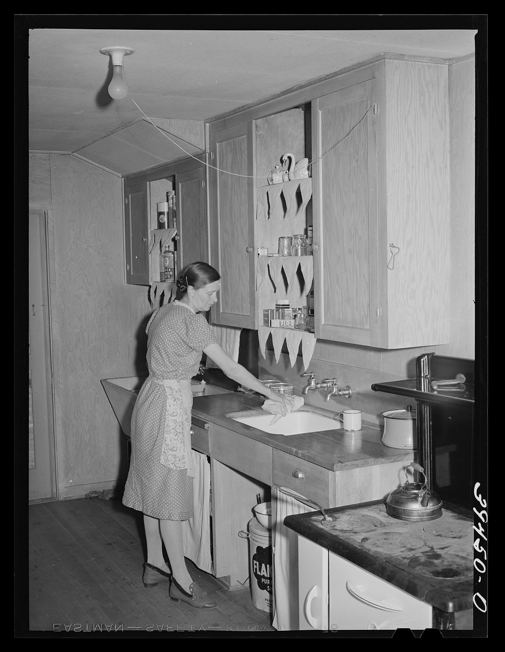 Wife of farm worker in kitchen of her cottage. Her husband is a "permanent" farm worker and they live in one of the cottages…
