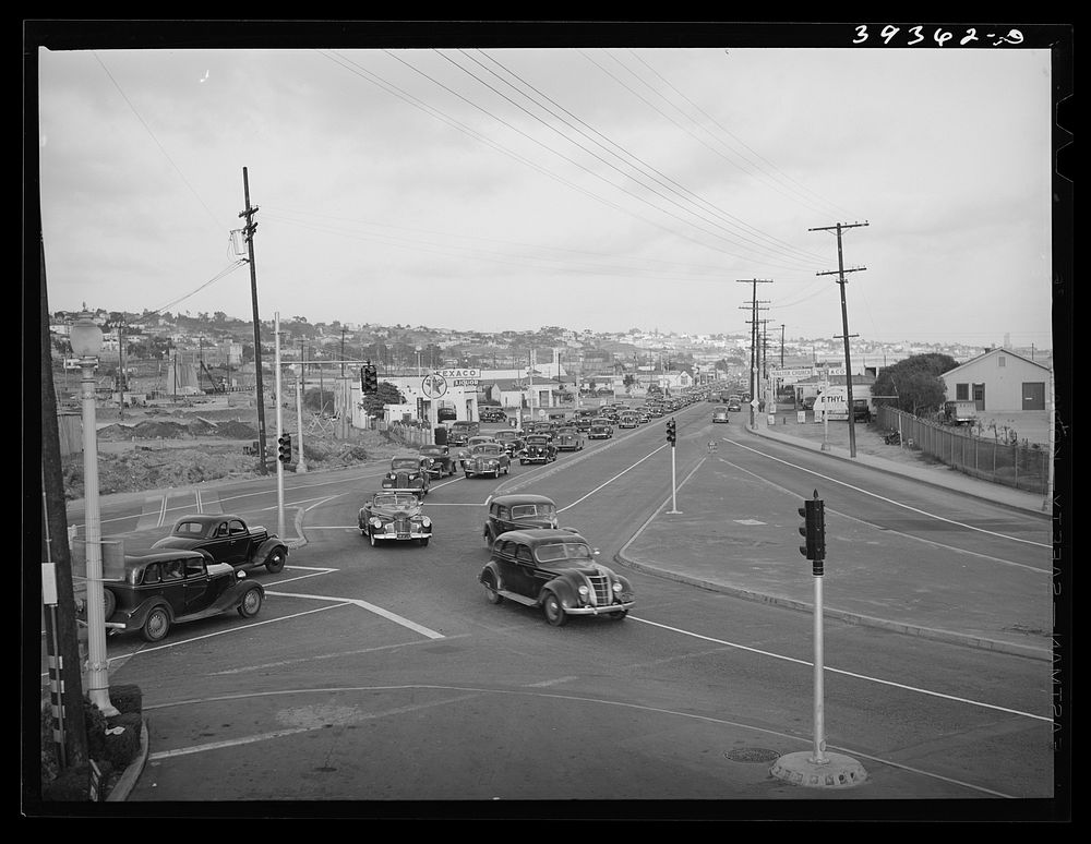 Traffic moving out of town on main highway when Consolidated Aircrafts changes shift in the afternoon. San Diego, California…