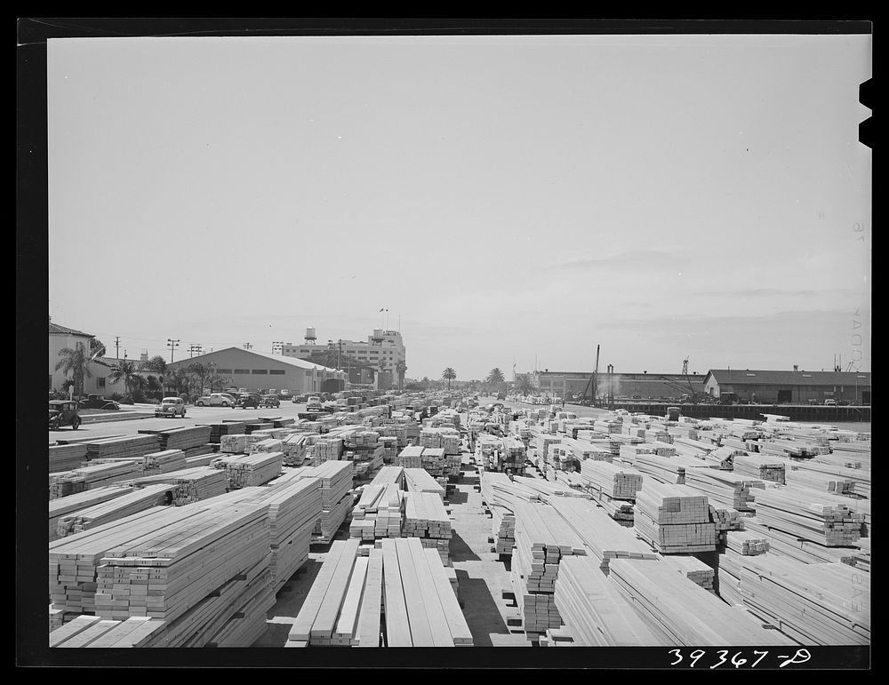 Lumber for construction work stacked in the open along Pacific Highway. San Diego, California by Russell Lee